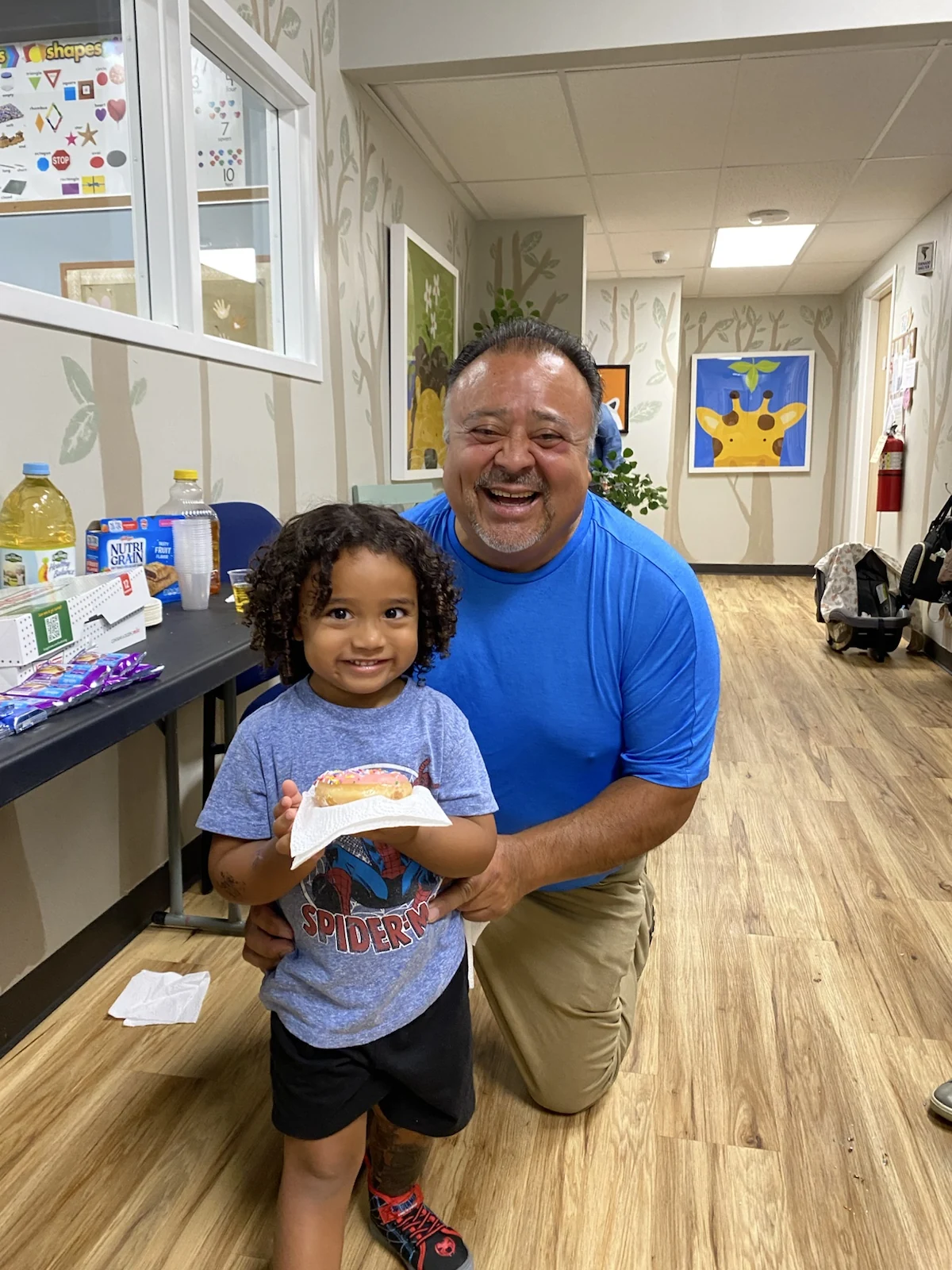 A smiling Wild Roots family member and child sharing a celebration together